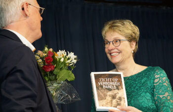 Jacob Keegstra overhandigt het eerste exemplaar van Zicht op Verborgen Parels aan Hennie Keegstra