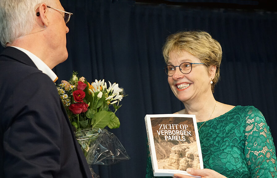 Jacob Keegstra overhandigt het eerste exemplaar van Zicht op Verborgen Parels aan Hennie Keegstra