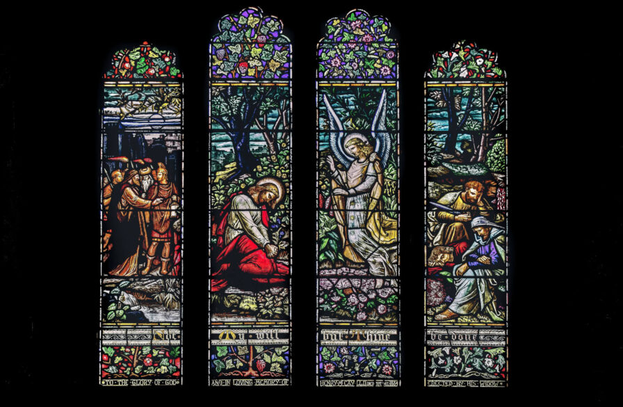 Stained glass windows in the cathedral depicting Jesus, his disciples, and an angel at Gethsemane as the Roman soldiers arrive to arrest him. (Credit: K. Mitch Hodge/Unsplash)